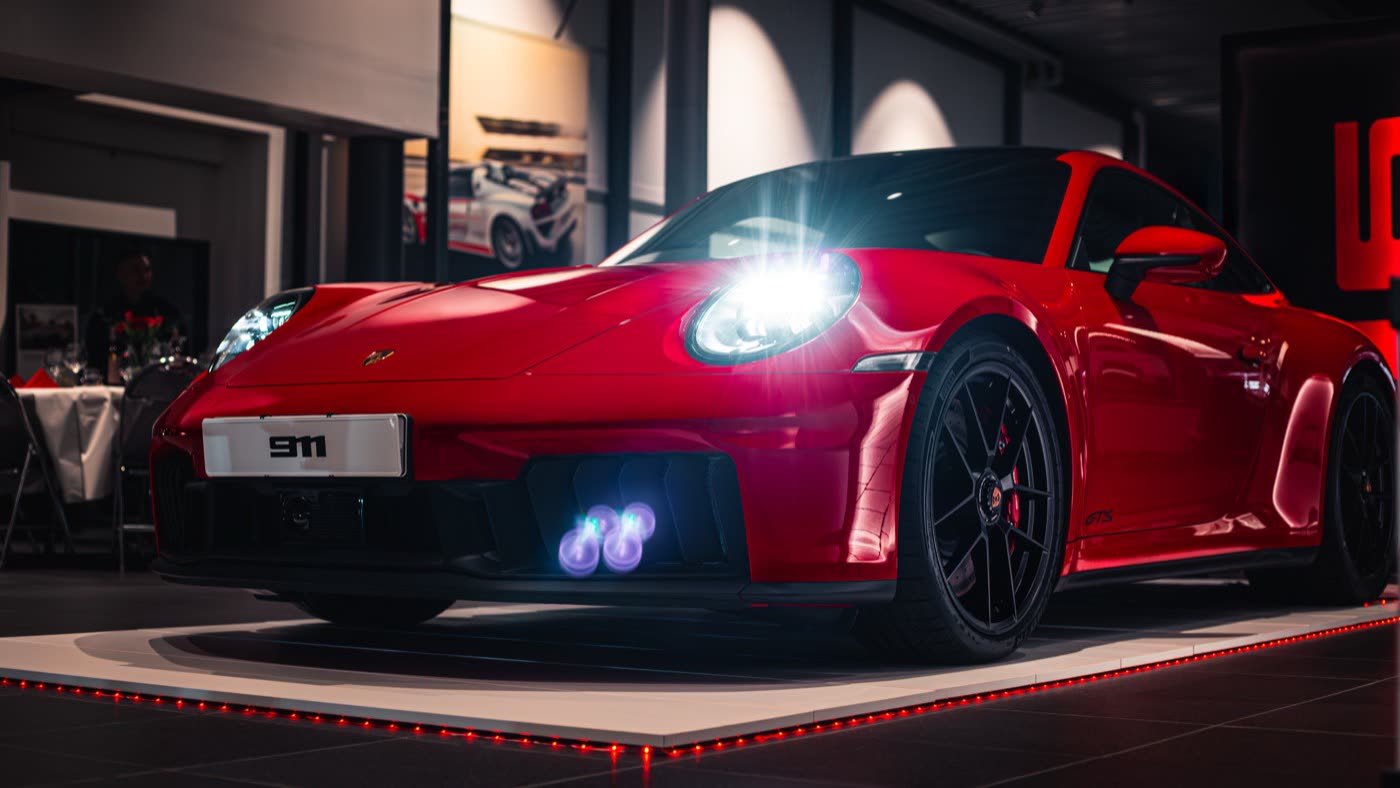 Red Porsche 911 Carrera GTS angled side view in Porsche Center Kalmar showroom