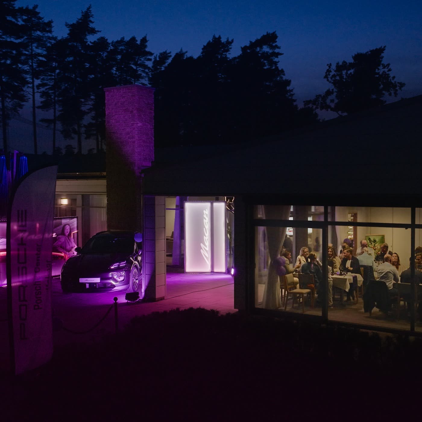 Porsche Macan Electric reveal at Porsche Center Kalmar — outdoor purple lighting at dusk