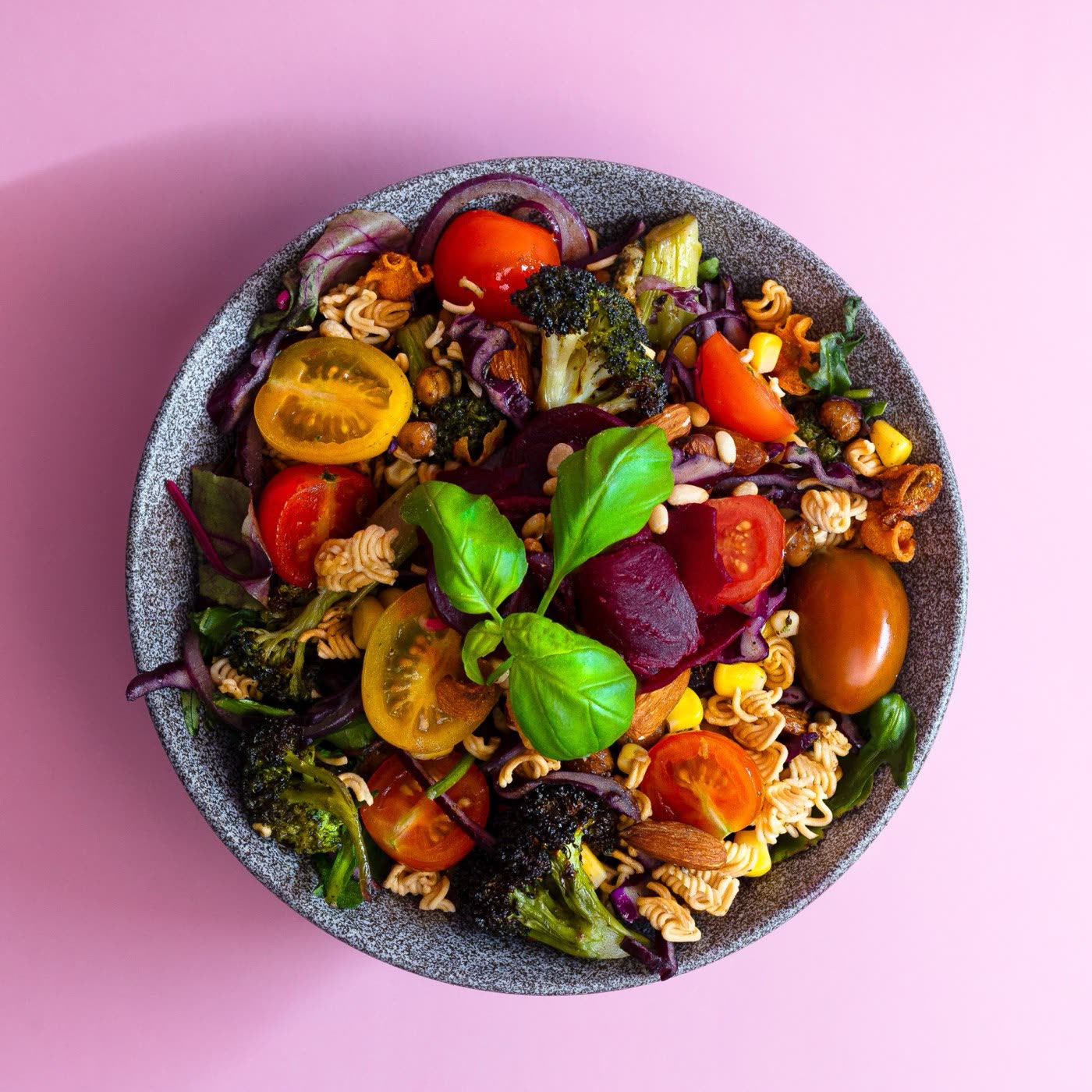 Colourful ramen noodle salad with cherry tomatoes, broccoli and beetroot in a stone bowl, Togo Kalmar