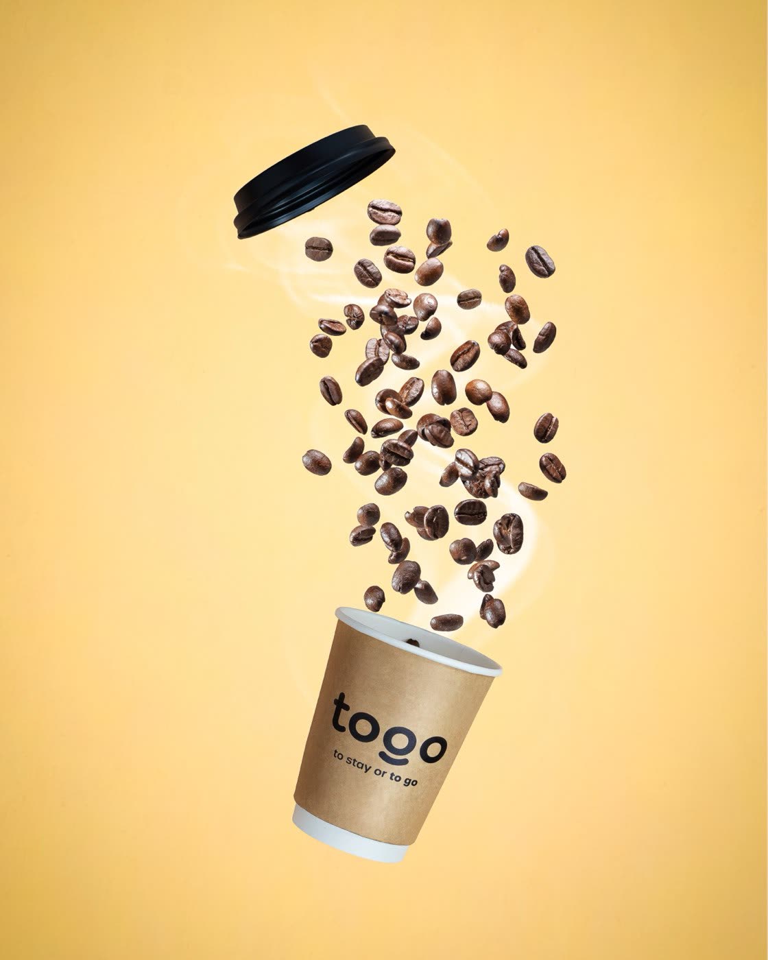 Togo Kalmar branded paper takeaway coffee cup with falling roasted coffee beans on yellow